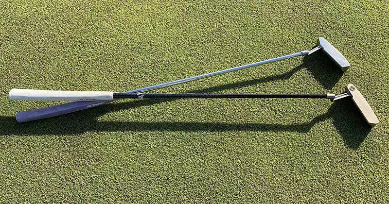 ゴルフ場の芝の上に2本のパターが置かれている画像です