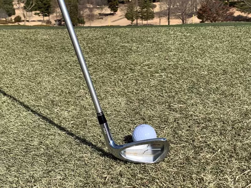 アイアンでボールを打つ構えの写真