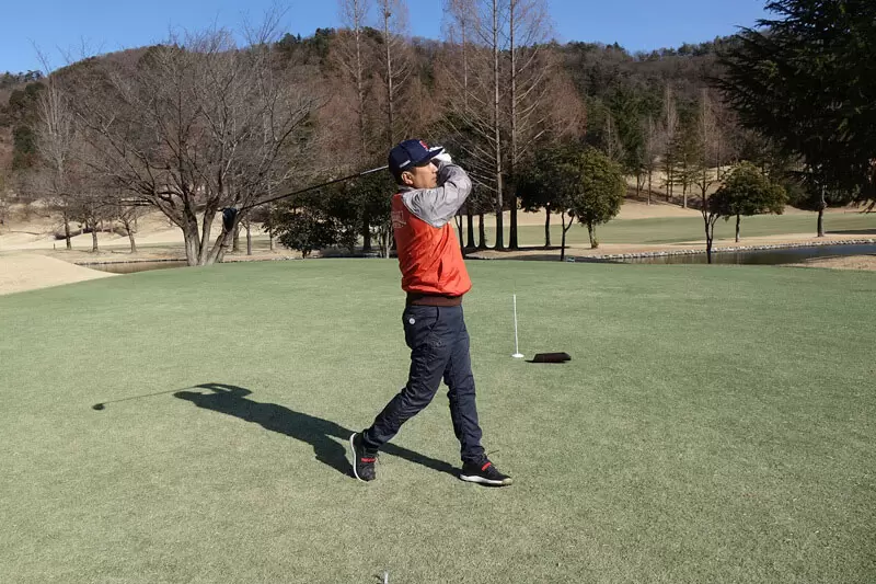 ゴルフ場での野村タケオのスイング写真