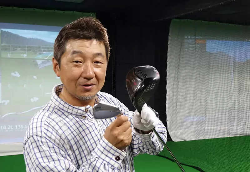 野村タケオがクラブを2本持ってクラブを見せるようにしている写真