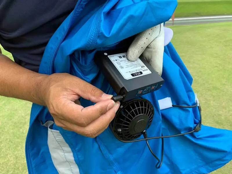 野村タケオがウェアにバッテリーを繋げている写真