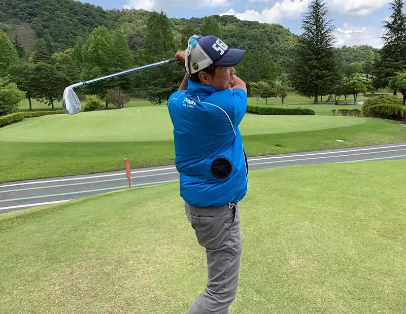 野村タケオがウェアを着てスイングしている写真