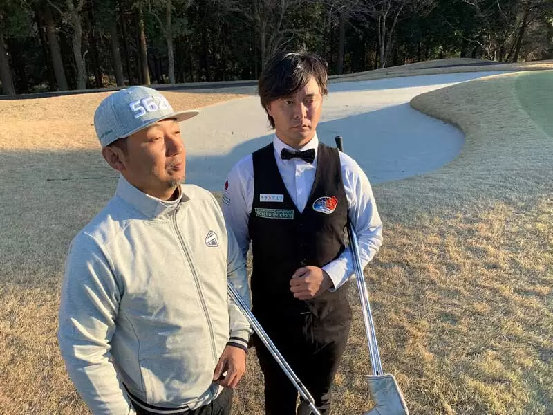 ゴルフ場で歩いている野村タケオと今野プロの2ショット写真