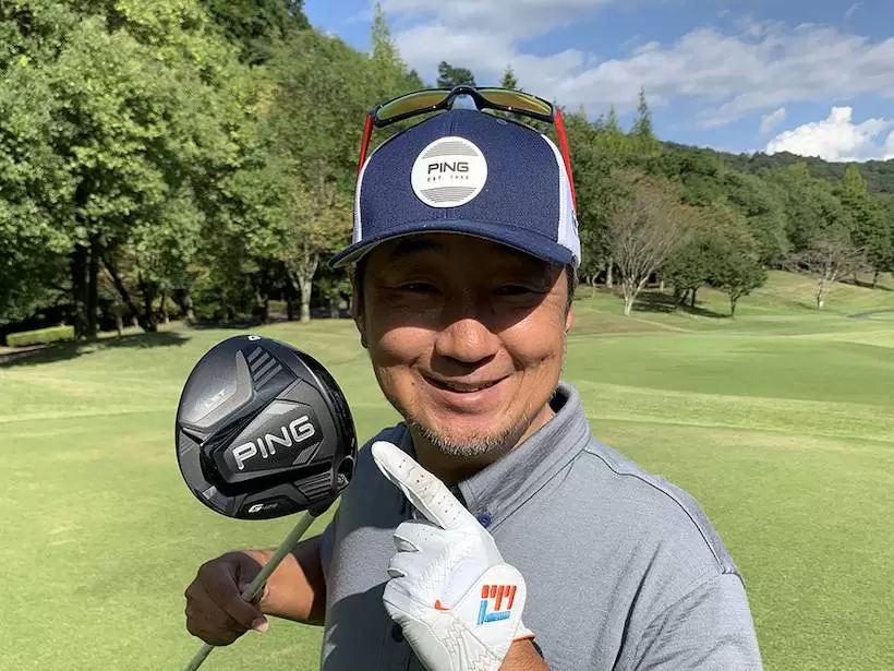 ゴルフ場で野村タケオがクラブを持って立っている写真