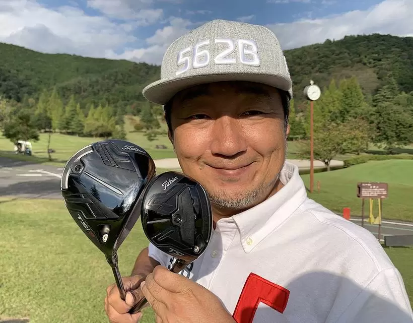 野村タケオがクラブを2本持って立っている写真