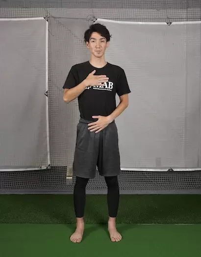 腹に置いた左手が動かないよう胸に置いた右手を動かす