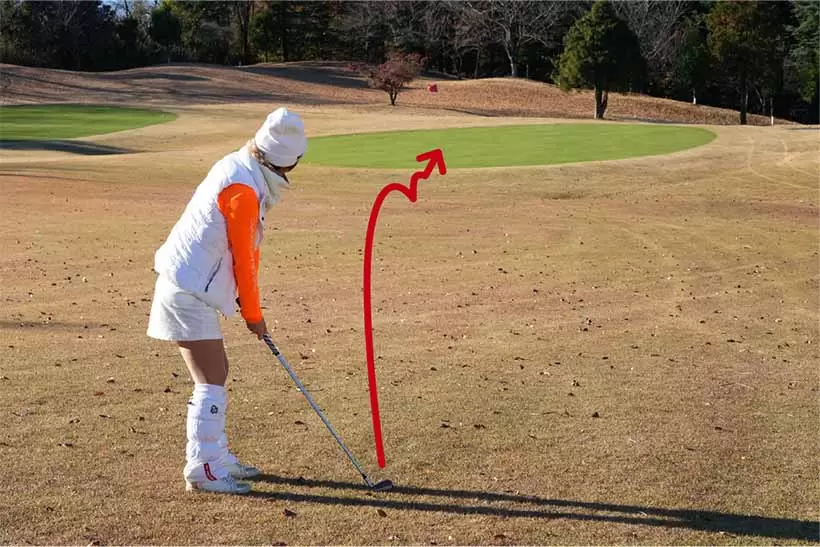 ピンまで70ヤード。しかも強い横風。こんな場面では最初から低くコロがす作戦が有効。