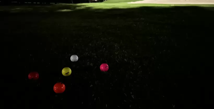 夜のゴルフ場にカラーゴルフボールを並べた写真