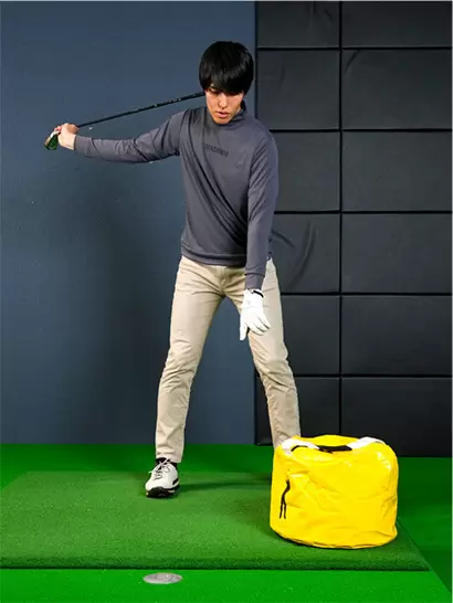 右手でクラブヘッド側を持ち、インパクトバッグを叩く練習をしよう。
