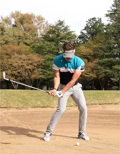 お腹に力を入れたままでダウンスイング。下半身が崩れず、クラブの入射角が安定する。