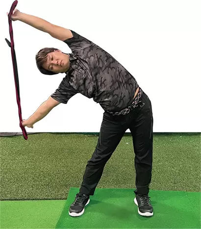 タオル等を持って肩幅に開き、グーッと横に倒れていく。最初に腰を突き出しておくと、腰のストレッチにならない。