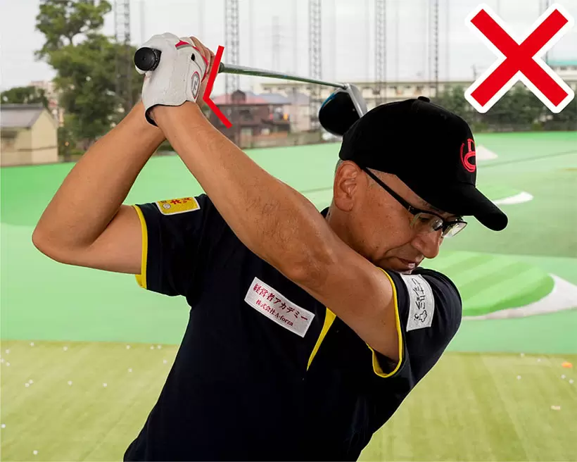 トップでも左手首が甲側に折れてクラブヘッドが目標の右を指すシャフトクロスとなる。