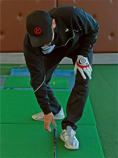 ボールが左カカト内側の前となるように立ち、クラブを左足の前に倒す。